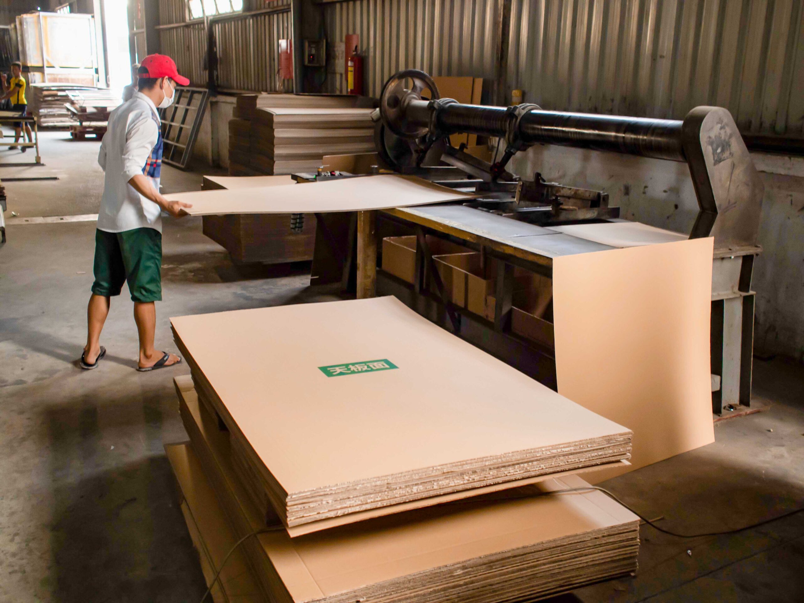 Worker cutting cardboard packaging